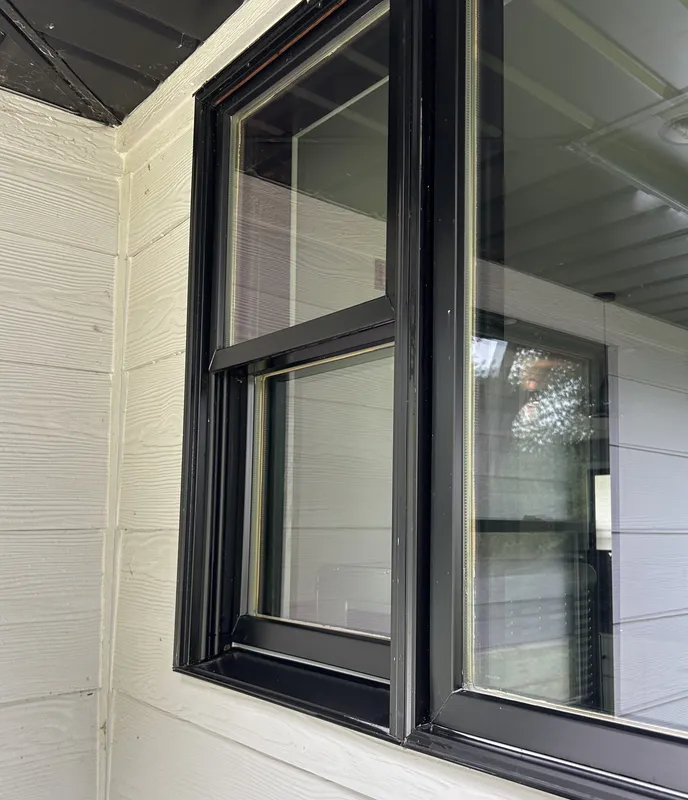 After: Black-framed window with cobwebs and grime